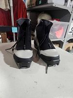 Front view of pair of Fischer cross-country ski boots showing zip lace covers and binding bars