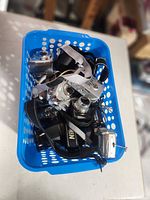 Top view of basket showing multiple compact digital cameras and DSLR body