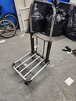 Cart upright with handle extended showing wheels and deck