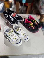 All three pairs of sneakers on tabletop