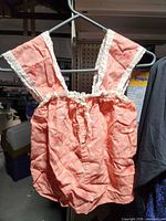 Front view of peach floral romper top on hanger