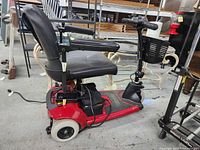 Full view of red three-wheel mobility scooter with seat and basket