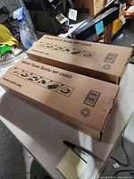 Two sealed boxes Waste Toner Bottle MP C6003 on table