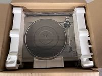 Turntable in original packing foam showing platter and dust cover