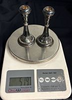 Pair of candleholders on scale showing weight 51.9 g