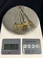 Six cocktail forks on digital scale reading 54.7 g