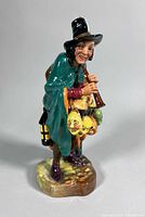 Front view of Royal Doulton The Mask Seller figurine showing full detail, masks and lantern