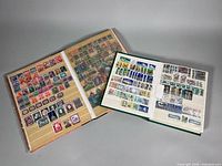 Overview of two open stamp albums showing pages filled with worldwide stamps