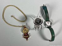Overview of three watches: Waltham cuff, Bosch wristwatch, floral pendant watch