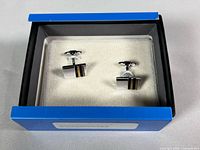 Open box showing both cufflinks on padded insert