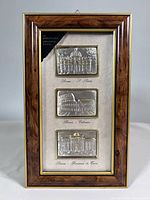Full view of framed silver plaques within wood frame