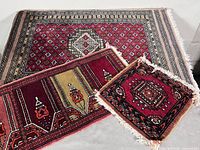 Three wool rugs stacked showing sizes and patterns