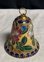 Front view of cloisonné bell showing floral and bird design, hanging loop visible