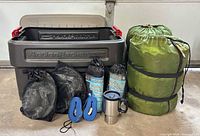 Full lot showing tote, sleeping bags, liners, straps, mug