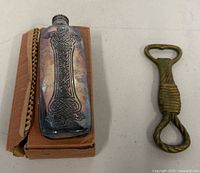 Flask on small box beside brass bottle opener
