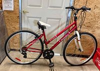 Left side view of red Everyday Kitsilano bicycle showing frame, wheels, drivetrain and brakes
