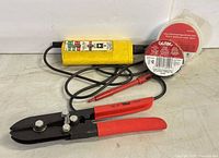 Voltage tester, pliers, two tape rolls grouped
