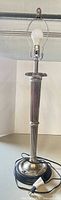 Full view of EPNS silver column table lamp with harp, finial, bulb and cord visible