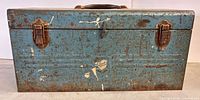 Front view of blue metal toolbox with latches and handle