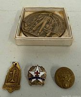 Top view of all four items including boxed American Legion medallion, valedictorian pin, Baptist star pin, US Marines pin