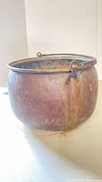 Full view of copper cauldron showing overall shape, bail handle and patina
