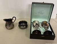 All four silver-plated items with presentation box; goblets inside box, creamer and bowl beside