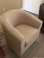 Front view of beige upholstered tub chair