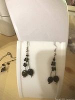 Black bead drop earrings on display stand