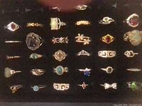 Overview of 32 costume rings arranged in black display case