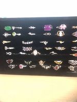 Front view of 38 assorted rings arranged in black velvet tray