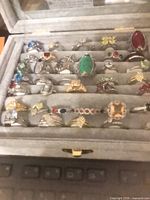 Open grey display case showing multiple costume rings