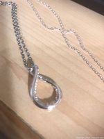 open loop pendant necklace on wood surface