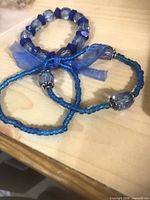 Three blue stretch bracelets tied together with ribbon