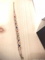 Gold-tone double-row bracelet with multicoloured stones and extender laid flat