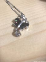 Blurred close-up of silver-plated pendant with dark stones (purple butterfly) on chain