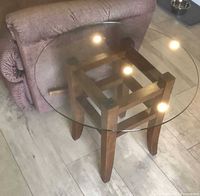 Pair of end tables showing round glass top and wooden base