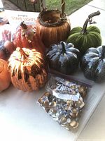 Assorted pumpkins, boxed stake lights, bag of small gold battery lights on table