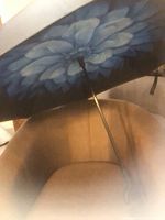 Umbrella open showing blue floral interior and metal shaft