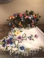 Butterfly candle ring and embroidered floral cutwork runner displayed on tabletop