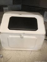 Front view closed showing white metal body, black insert on upper door