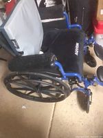 Side view of blue Drive wheelchair showing Auvon cushion, wheel, armrest, leg rests