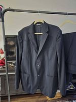 Front view of jacket on hanger with trousers visible