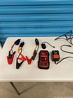 Overall lot showing inverter, charger and clamp cables on table