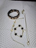 Overview of four jewelry pieces laid out on white mat