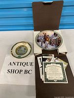 Both plates shown with paperwork and box