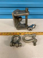 Hitch mount, tow ball and two shackles beside ruler for scale