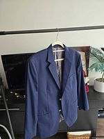 Front view of navy blazer on hanger showing overall style and color