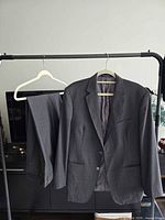 Full view of jacket and trousers on rack