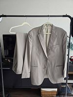 Full view of jacket and trousers on hanger