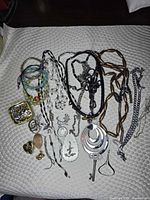 Full layout of assorted necklaces, bracelets, pendants, charms on white mat